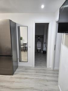 a hallway with a bathroom with a toilet and a mirror at Apartament confortabil, ideal pt 2 adulti si 2 copii sau 3 adulti in Râmnicu Vâlcea +14 photos