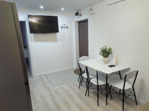 a dining room with a white table and chairs at Apartament confortabil, ideal pt 2 adulti si 2 copii sau 3 adulti in Râmnicu Vâlcea