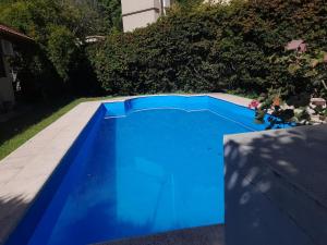 a blue swimming pool in the backyard of a house at Emmac Zen in Ciudad Lujan de Cuyo