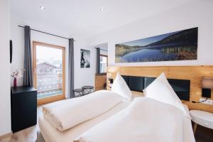 a bedroom with two beds and a large window at Pension Bavaria in Mittenwald