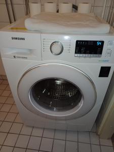 a white washing machine sitting in a bathroom at Air conditioned Apartment in Espoo