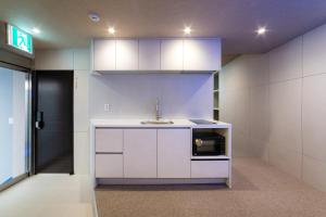 a kitchen with a sink and a microwave at 해치 호스텔 in Seoul