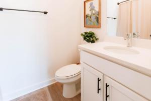 a white bathroom with a toilet and a sink at Artist Retreat Near Downtown, Stadium & UGA in Athens +27 photos