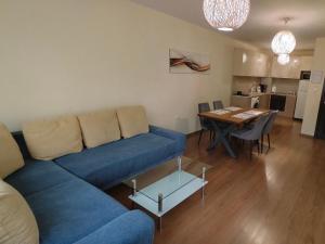 a living room with a blue couch and a table at HostEx Trinity Apartment in Stara Zagora