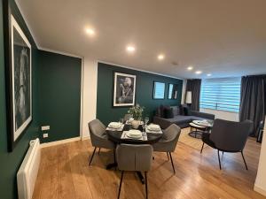 a living room with a table and chairs and a couch at GRAPHITE APARTMENTS in Inverness +5 photos