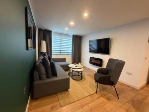 a living room with a couch and a chair at GRAPHITE APARTMENTS in Inverness