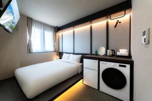 a hotel room with a bed and a washing machine at 해치 호스텔 in Seoul