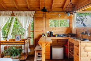 a kitchen in a log cabin with a table at Refugio para desconectar, cabaña del ermitaño en medio del bosque in La Ceja