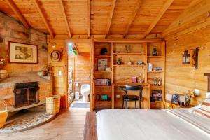 a log cabin bedroom with a bed and a fireplace at Refugio para desconectar, cabaña del ermitaño en medio del bosque in La Ceja +19 photos