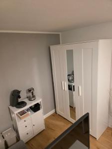 a room with a white cabinet and a mirror at Apartment Tanne in Düsseldorf