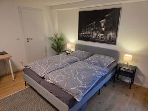 a bedroom with a bed and two night stands with lamps at Apartment Tanne in Düsseldorf