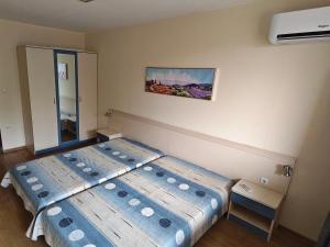a bedroom with two beds and a painting on the wall at HostEx Trinity Apartment in Stara Zagora