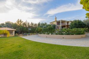 a large yard with a building and a house at Apeiron Villas - Olive Forest Apartment in Kefallonia