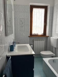a white bathroom with a sink and a toilet at Casa I Limoni in Viareggio +22 photos