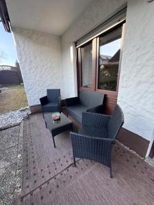 a patio with chairs and a table and a window at Wagner Apartment Bayreuth FeWo - Erdgeschoss - nähe Festspielhaus - Free-WiFi - Schlafzimmer - Boxspringbetten - große Küche - Dusche - Badewanne - extra WC - Terrasse - DTV-Zertifiziert in Bayreuth