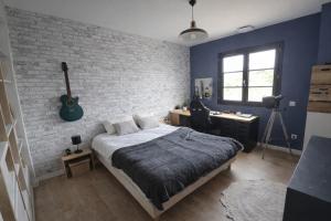 a bedroom with a bed and a brick wall at Villa Signature in Le Bosc +16 photos