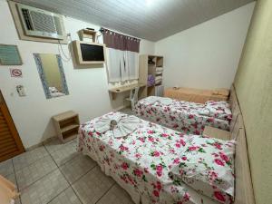 a small room with two beds and a tv at Pousada Jubaia in Bonito +61 photos
