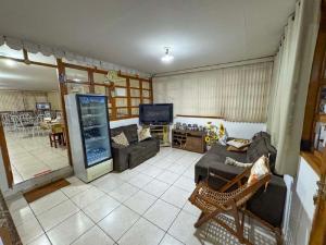 a living room with a couch and a tv at Pousada Jubaia in Bonito