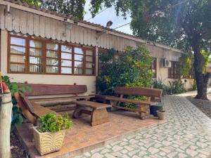 a patio with two wooden benches in front of a building at Pousada Jubaia in Bonito