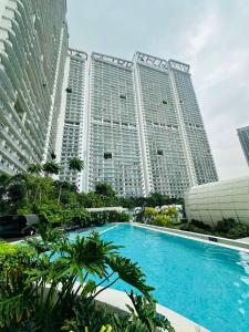 a pool in front of two tall buildings at Novotel Executive Hotel at Rosalina Acqua Residence Mandaluyong in Manila