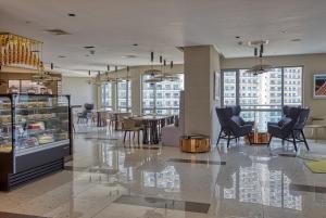 a restaurant with chairs and tables in a building at Novotel Executive Hotel at Rosalina Acqua Residence Mandaluyong in Manila
