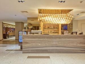 a restaurant with a bar with a chandelier at Novotel Executive Hotel at Rosalina Acqua Residence Mandaluyong in Manila +71 photos