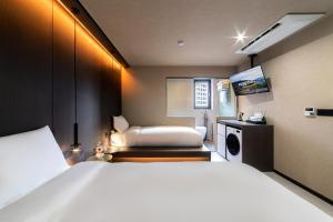 a hotel room with a bed and a chair at 해치 호스텔 in Seoul