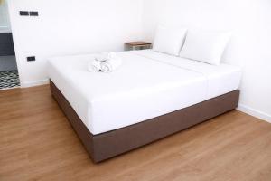 a white bed with two white pillows on it at Travellers Palm in Ko Phangan