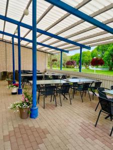 a group of tables and chairs under a roof at Hotelli Puustelli Lieksa in Lieksa