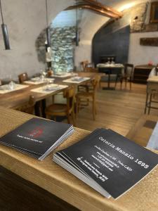 a table with two menus on top of a restaurant at Mansio 1695 Chambres d'hôtes in Pont-Saint-Martin +15 photos