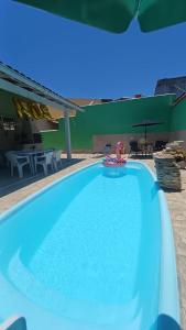 a large blue swimming pool with a toy in the water at Família Castro Ostras in Rio das Ostras