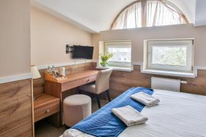 a bedroom with a bed and a desk with a computer at Villa Sulejówek in Sulejówek