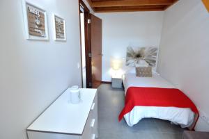 a bedroom with a bed with a red blanket at El Baladero in Telde