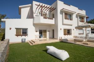 a white house with a lawn in front of it at The Sandy Feet Sea Front in Hurghada
