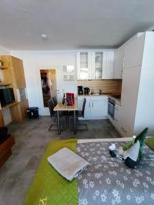 a kitchen and a living room with a bed and a table at Studio Almwiese in Kaprun