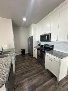a kitchen with white cabinets and a stove and refrigerator at Spacious Family Townhouse in Edmond +7 photos
