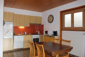 a kitchen with a wooden table and a table and chairs at Anzère appartement de vacances calme et sympa in Anzère