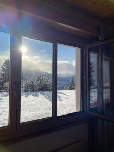 a window with a view of a snow covered mountain at Anzère appartement de vacances calme et sympa in Anzère