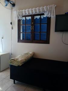 a room with a window and a bench with a television at Chalé Romântico in Extrema
