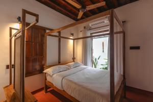 a bedroom with a canopy bed and a window at The Oneness Living- Seasonal Heritage stay with Tholpaavakoothu nights in Pazhayannūr
