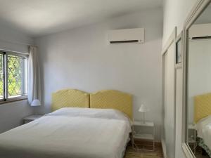 a white bedroom with a bed and a window at Casa Nicho in Vale do Lobo +18 photos