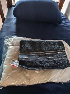 a black bag sitting on top of a bed at Jandira Hosting Acomodação in Jandira