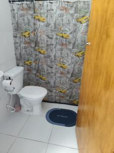 a bathroom with a toilet and a shower curtain with yellow cars at Jandira Hosting Acomodação in Jandira +4 photos