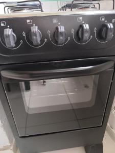 a black stove top oven with its door open at Jandira Hosting Acomodação in Jandira