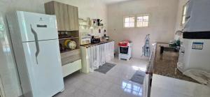 a kitchen with a large white refrigerator in a room at Família Castro Ostras in Rio das Ostras