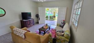 a living room with two couches and a tv at Família Castro Ostras in Rio das Ostras