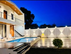 a villa with a swimming pool at night at Vasudeva Villas in Udaipur