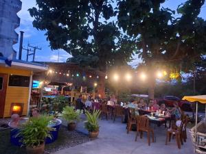 a group of people sitting at a restaurant at night at Harry's Beach Club in Ban Phe