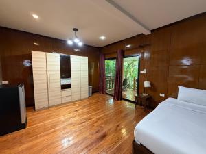 a bedroom with a bed and a wooden floor at Kiriraya Resort in Ao Nang Beach