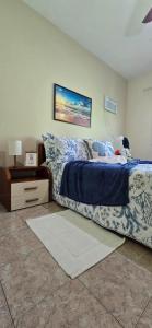 a bedroom with a bed with blue and white sheets and a table at Família Castro Ostras in Rio das Ostras +75 photos